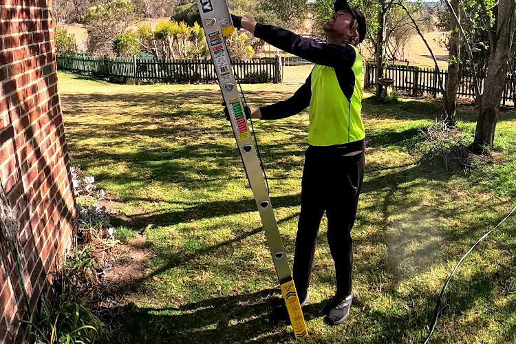 Seasoned expert in gutter cleaning assembles their extension ladder in batemansbay.